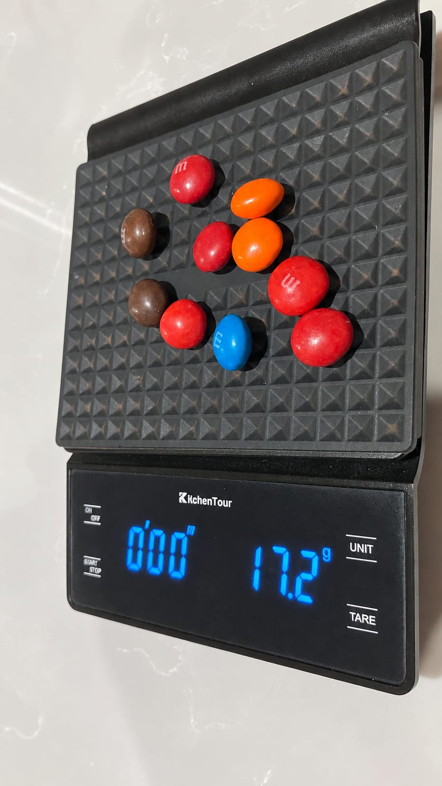 Ten peanut butter M&Ms on a kitchen scale reading 17.2 g