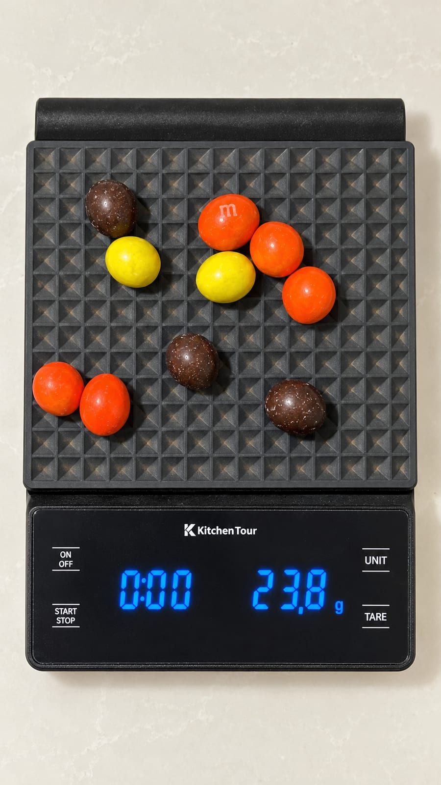 Ten peanut M&Ms on a kitchen scale reading 23.8 g